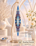 The Key of Oialis blue-and-gold beaded spindlepod on a curved gold stand beside white orchids.